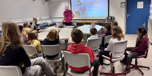Frau Hohmann erklärt den Kindern vor der Leinwand die Zahnpflege